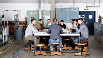 The picture shows a group of male students in a meeting-room of the Faculty of Mechanical and Process Engineering.